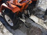 a man standing next to a tractor with a snow plow attached to it