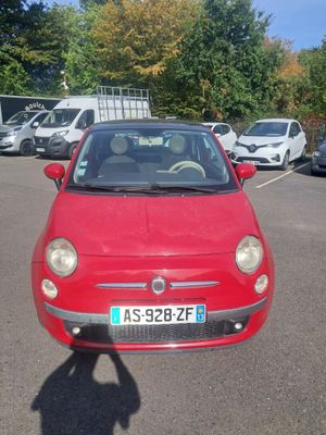 a small red car that is parked in a parking lot