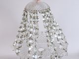 quelqu'un tient un sac à main orné de perles et muni d'une chaîne
