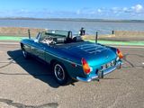 a blue convertible car parked on the side of the road