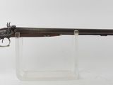 un fusil avec un canon en bois sur un support transparent