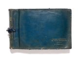 un vieux livre à la couverture bleue posé sur une surface blanche