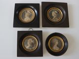 trois portraits encadrés représentant un homme et une femme, posés sur une table blanche
