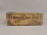 une vieille boîte en bois sur laquelle est collée une étiquette portant l'inscription « Mouton Cadet »