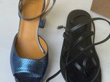 two pairs of black and blue shoes are next to a cardboard box