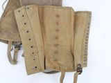 three tan leather gaiters with rivets on them sitting on a white surface