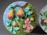 two decorative plates with fruit and flowers on them