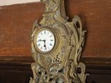a clock on a shelf in the corner of a room