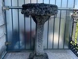 a bird bath sitting on top of a stone pedestal