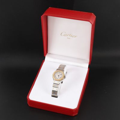une montre dans un coffret rouge posé sur un fond noir