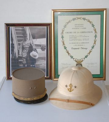 a hat on a table next to a picture of a soldier