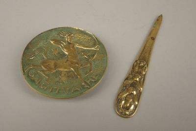 une cuillère en or posée à côté d'une pièce d'or sur une table