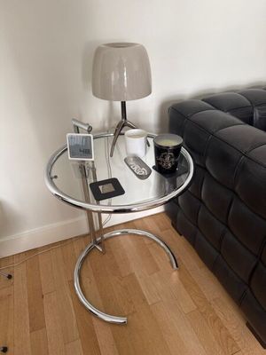 une table en verre sur laquelle est posé un téléphone portable, dans un salon