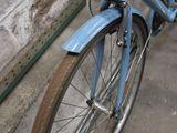 a blue bicycle parked next to a brick wall