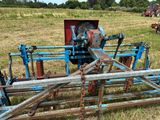 une charrue bleue qui est posée dans l'herbe