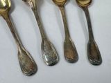 six silver spoons are lined up in a row on a white surface
