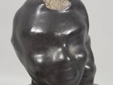 statue of a child with a gold disc on his head