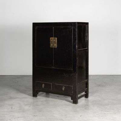 une image représentant une armoire noire à deux portes et deux tiroirs