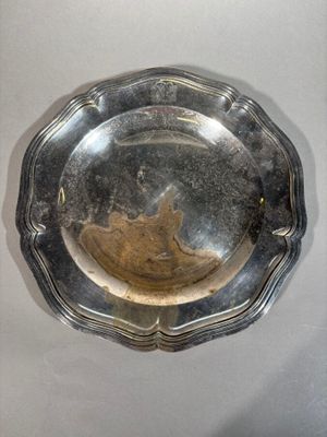 a silver plate on a wall with a bird on it