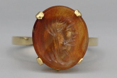 une image représentant une bague en or sur laquelle est gravée la silhouette d'une femme
