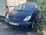 une petite voiture bleue garée devant un garage