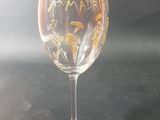 a wine glass with a gold design on it on a table
