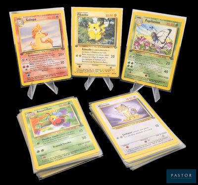 Quatre cartes Pokémon sont exposées sur une surface noire.
