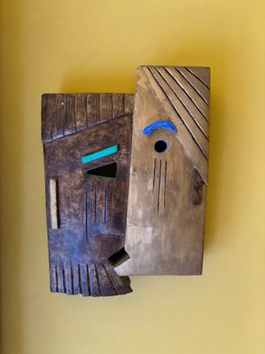 un masque en bois accroché au mur d'une pièce