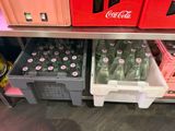 bottles of soda and soft drinks are stacked on a shelf in a store