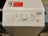 a white washing machine sitting on top of a table