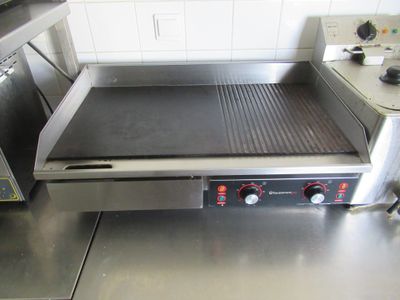 un plan de travail en acier inoxydable équipé d'une plaque de cuisson électrique, dans une cuisine professionnelle