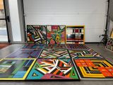 une pièce où il y a plein de tableaux de différentes couleurs posés par terre
