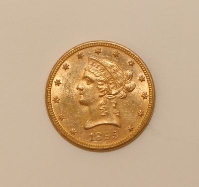 a close up of a gold coin on a white surface