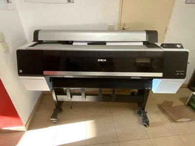 une grande imprimante posée sur un support dans une pièce