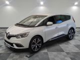 une voiture blanche garée dans un garage au sol en damier