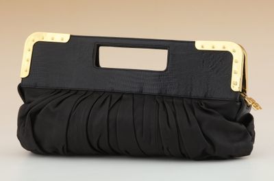 a black purse with a gold handle on a white surface