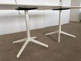 a white table with a black top and two white legs