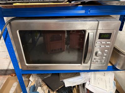 a microwave sitting on top of a blue shelf