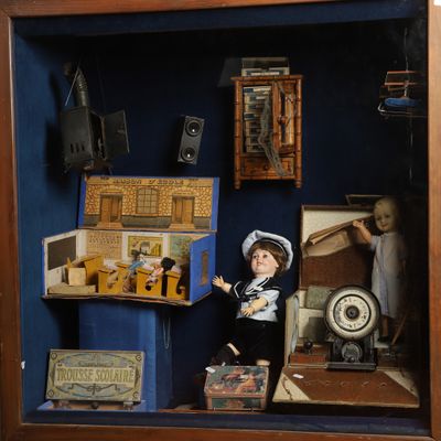 un cadre-vitrine contenant une poupée