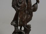 bronze statue of a woman with a basket of flowers on a pedestal