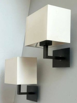 two lamps that are on the wall next to each other