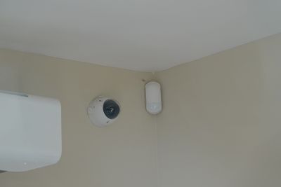 une photo d'une salle de bains avec des toilettes et un distributeur de papier toilette fixé au mur