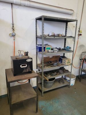 a room with a shelf and a table with tools on it