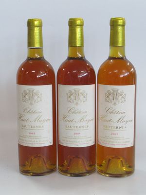 trois bouteilles de vin posées les unes à côté des autres sur une surface blanche