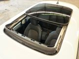 a white car with a sunroof sitting in a garage