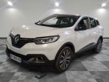 la voiture blanche est garée sur un sol en damier dans le garage