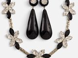 a close up of a necklace and earrings on a white background