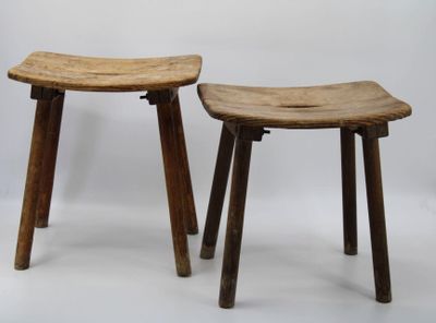 two wooden stools sitting next to each other on a white surface