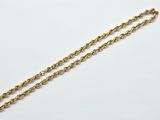 a close up of a gold chain on a white surface