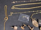a lot of gold jewelry on a black table